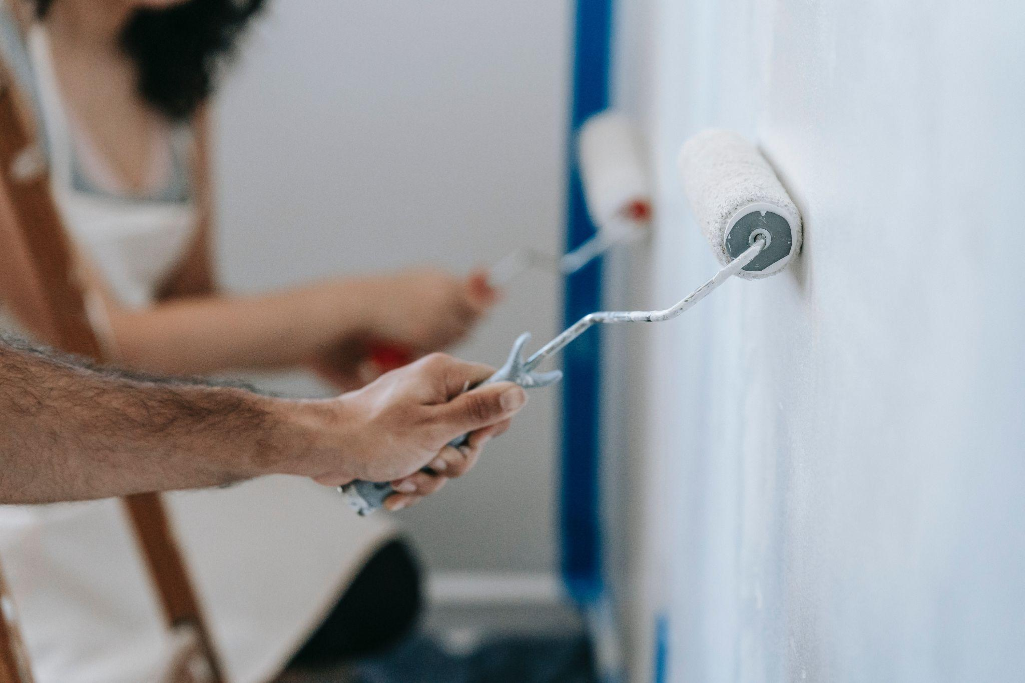 Two people repainting the wall