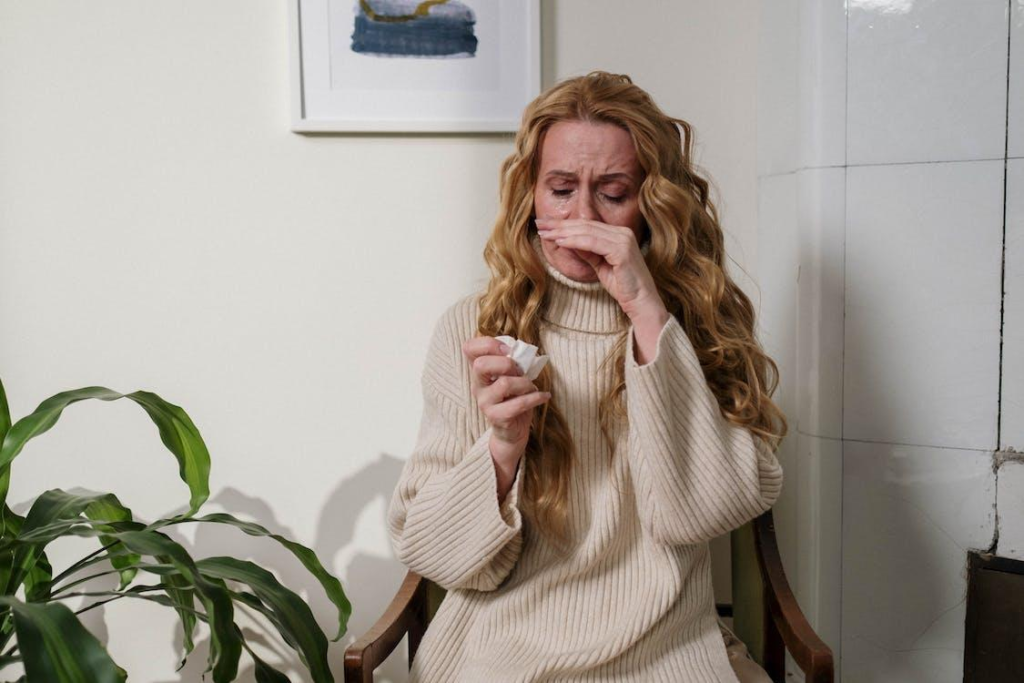 A young woman suffering from allergies in her home