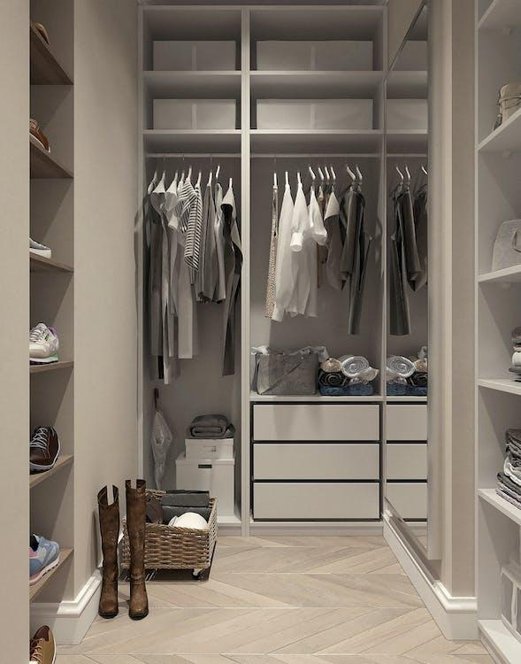 A small walk-in closet with assorted clothes