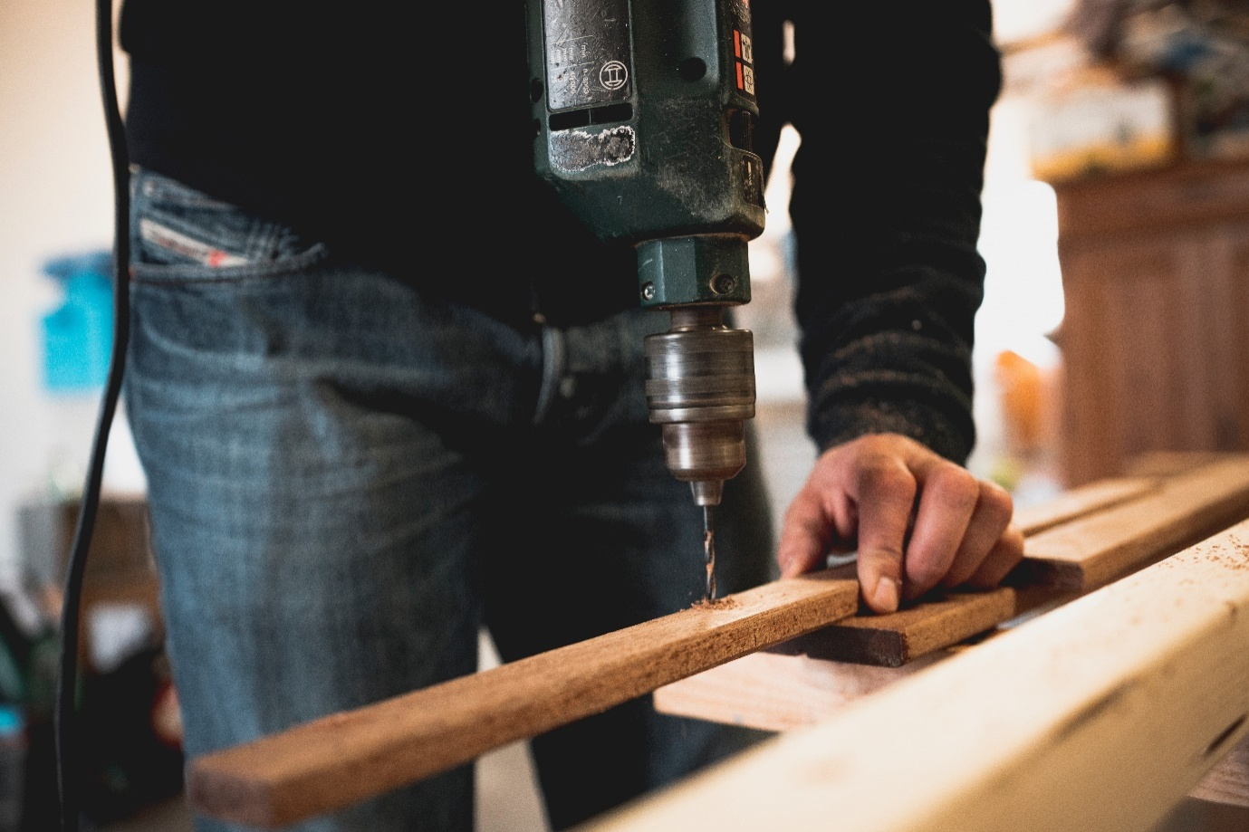 A person using a drill machine for a home repair projects