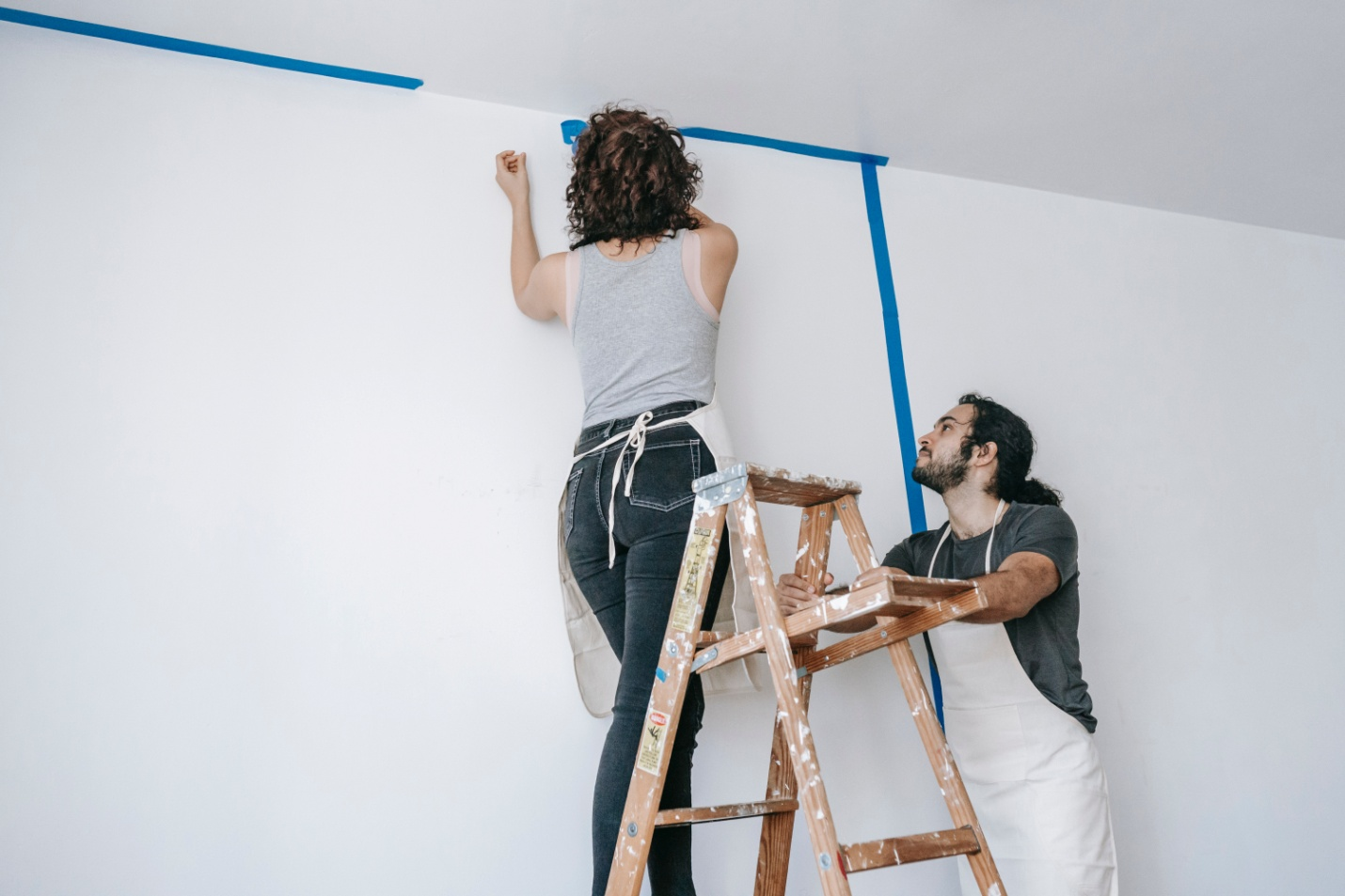 A man helping a woman with DIY painting for home improvement