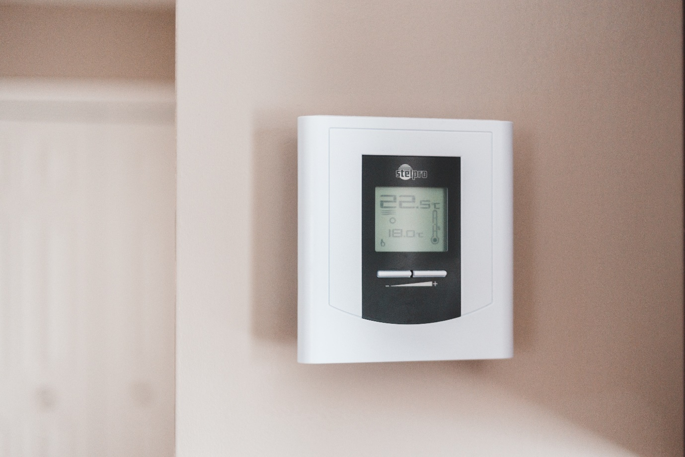 A thermostat hanging on a wall to control relative humidity